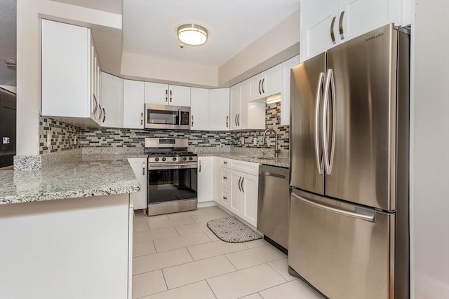 kitchen featuring white cabinets, tasteful backsplash, appliances with stainless steel finishes, and a sink