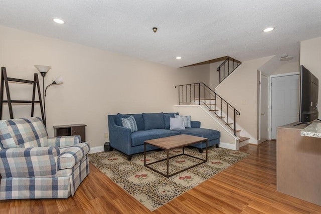 living room with stairs, recessed lighting, wood finished floors, and baseboards