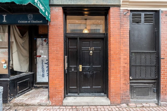 view of exterior entry with brick siding