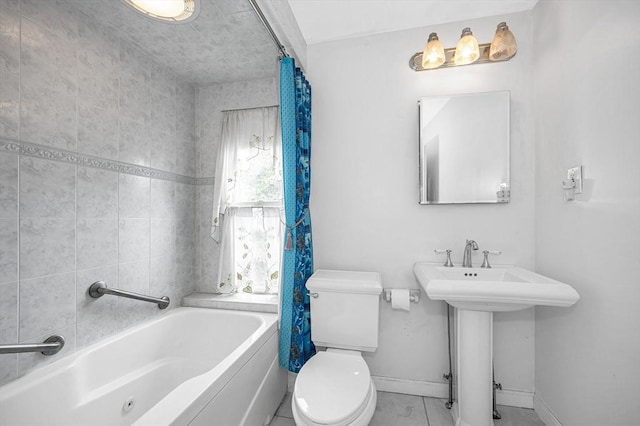 bathroom featuring toilet, baseboards, shower / bathtub combination with curtain, tile patterned flooring, and a sink