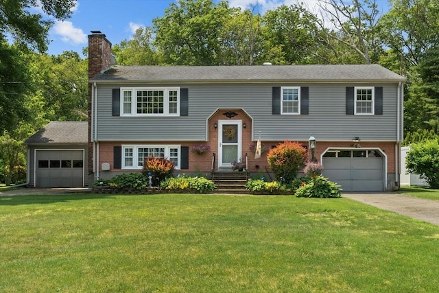 15 Cushing St, Salisbury, MA 01952 - split foyer home with a chimney, asphalt driveway, a front lawn, brick siding, and an attached garage