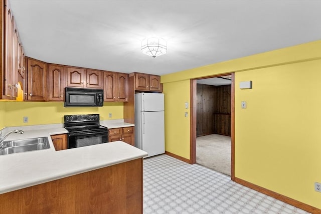 15 Cushing St, Salisbury, MA 01952 - kitchen featuring black appliances, light countertops, brown cabinetry, light colored carpet, and a peninsula