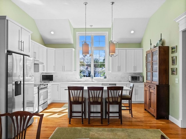 8 Sandstone Dr Unit 8, Medway, MA 02053 - kitchen with appliances with stainless steel finishes, backsplash, a sink, a breakfast bar, and light countertops