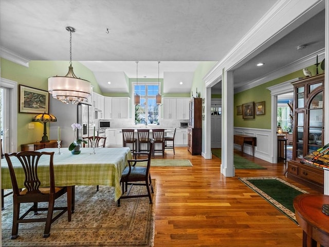 8 Sandstone Dr Unit 8, Medway, MA 02053 - dining space with light wood-style floors, a wainscoted wall, crown molding, and a chandelier