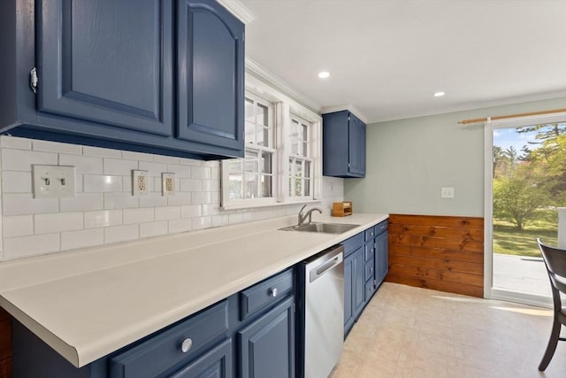 kitchen with wainscoting, a sink, dishwasher, light countertops, and blue cabinetry