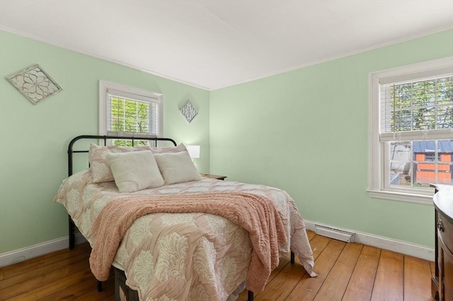 bedroom featuring baseboards, a baseboard radiator, and hardwood / wood-style flooring