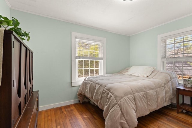 bedroom with baseboards, ornamental molding, and hardwood / wood-style floors