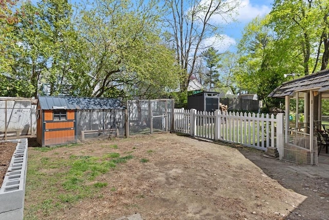 view of yard with a fenced backyard, exterior structure, an outbuilding, and a storage shed