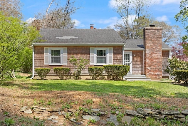 view of front of house with a chimney, roof with shingles, and a front lawn
