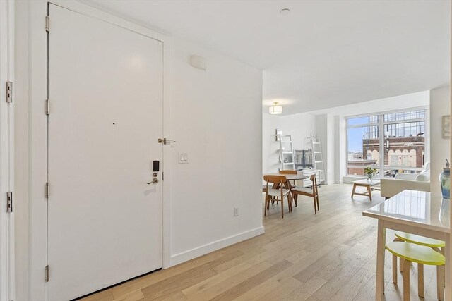 entrance foyer featuring light wood-type flooring and baseboards