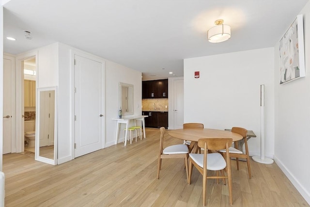 dining room with light wood finished floors, recessed lighting, and baseboards