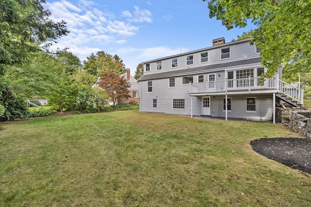 back of house featuring a lawn, a chimney, and a wooden deck