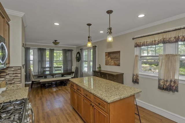 51 Stratford Ter, Springfield, MA 01108 - kitchen featuring brown cabinetry, crown molding, wood finished floors, a center island, and pendant lighting