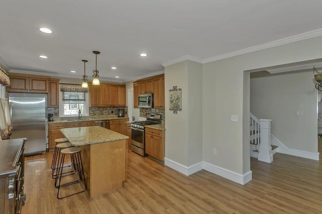 51 Stratford Ter, Springfield, MA 01108 - kitchen with appliances with stainless steel finishes, crown molding, light wood-type flooring, decorative backsplash, and a sink