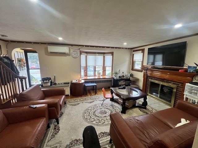 living area with arched walkways, wood finished floors, a wall mounted AC, a brick fireplace, and radiator