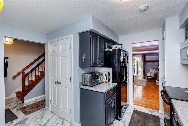 1102 Foxwood Cir Unit 1102, Peabody, MA 01960 - kitchen with black appliances, light countertops, a textured ceiling, light marble finish flooring, and baseboards