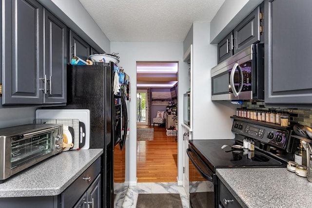 1102 Foxwood Cir Unit 1102, Peabody, MA 01960 - kitchen with black appliances, light marble finish floors, a textured ceiling, light countertops, and tasteful backsplash