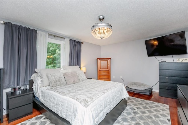 1102 Foxwood Cir Unit 1102, Peabody, MA 01960 - bedroom featuring wood finished floors, a chandelier, baseboards, and a textured ceiling