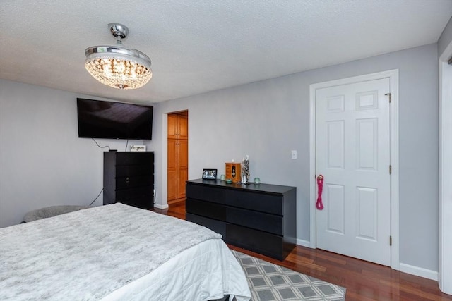 1102 Foxwood Cir Unit 1102, Peabody, MA 01960 - bedroom featuring dark wood-style flooring, a chandelier, baseboards, and a textured ceiling