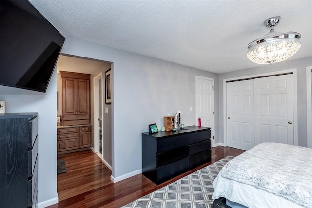 1102 Foxwood Cir Unit 1102, Peabody, MA 01960 - bedroom with dark wood-style flooring, a chandelier, a closet, baseboards, and a textured ceiling