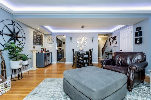 1102 Foxwood Cir Unit 1102, Peabody, MA 01960 - living room with stairs, light wood finished floors, a raised ceiling, baseboards, and a bar
