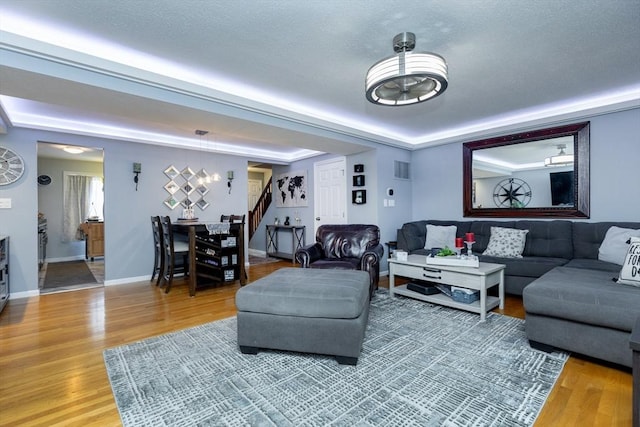 1102 Foxwood Cir Unit 1102, Peabody, MA 01960 - living area featuring stairs, light wood-type flooring, a raised ceiling, and baseboards