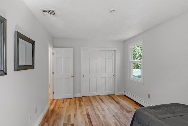 6 Candida Ln, Acton, MA 01720 - bedroom with a baseboard radiator, light wood-style floors, and a closet