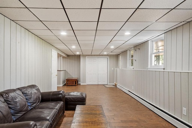 6 Candida Ln, Acton, MA 01720 - living area with a baseboard radiator, wood-type flooring, wooden walls, recessed lighting, and a drop ceiling