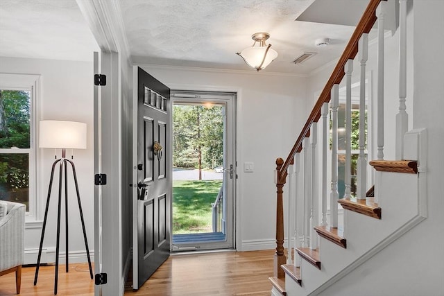 6 Candida Ln, Acton, MA 01720 - entrance foyer with stairway, light wood-type flooring, crown molding, and baseboard heating