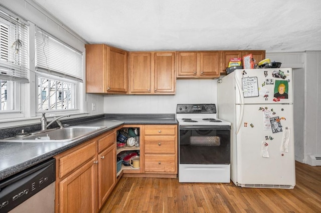 kitchen featuring sink, baseboard heating, white appliances, and light wood-type flooring