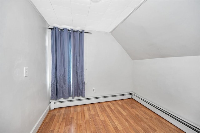 additional living space featuring a baseboard radiator, hardwood / wood-style floors, and lofted ceiling