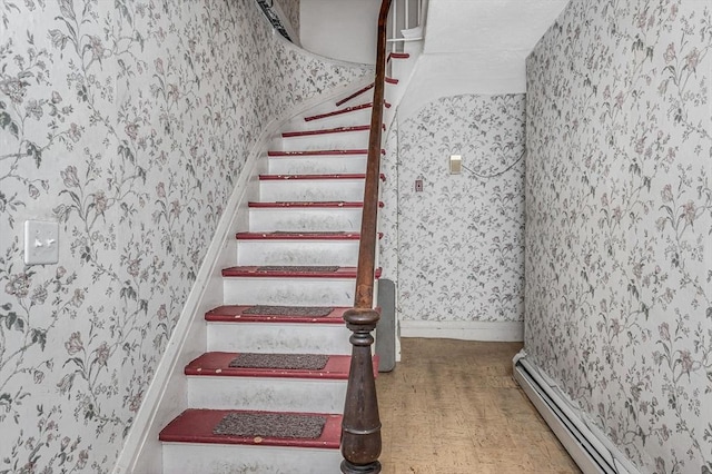 staircase featuring a baseboard heating unit