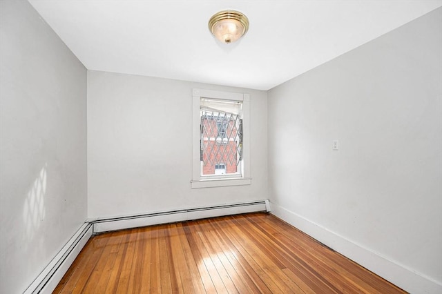 unfurnished room featuring hardwood / wood-style floors and baseboard heating