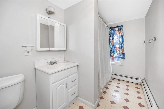 bathroom with vanity, toilet, and a baseboard heating unit