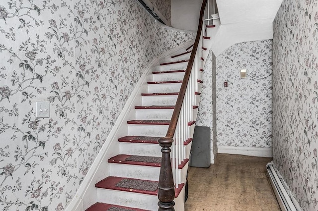 staircase featuring parquet floors and a baseboard heating unit