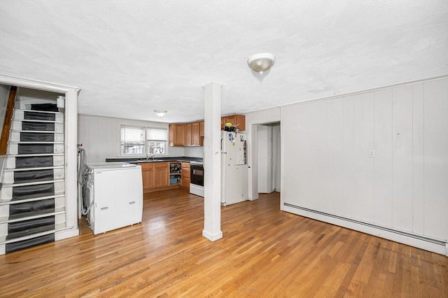 kitchen with light hardwood / wood-style flooring, a baseboard heating unit, a textured ceiling, electric range, and white fridge