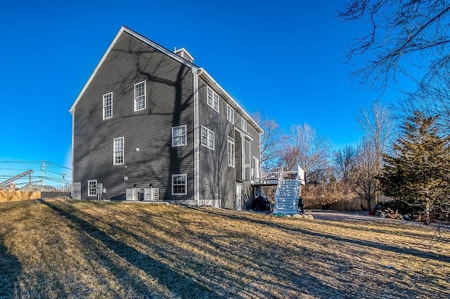 view of home's exterior with a yard and stairway