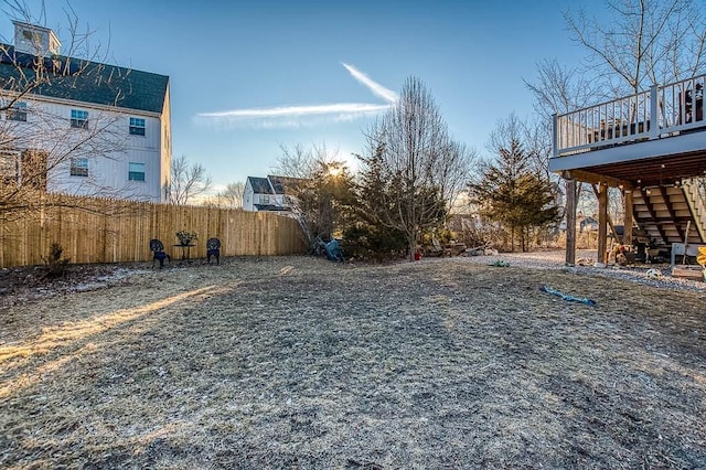view of yard featuring fence, a deck, and stairs