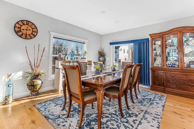 dining area featuring light wood-style flooring and baseboards