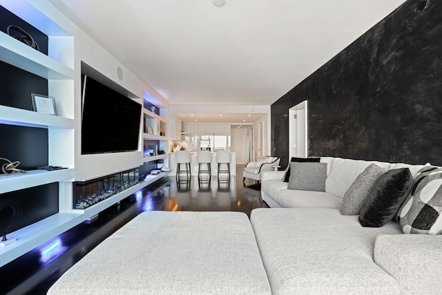 living room featuring built in shelves and dark hardwood / wood-style floors