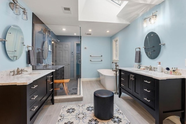 bathroom with a shower stall, visible vents, a sink, and a soaking tub