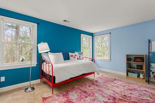 carpeted bedroom featuring baseboards, multiple windows, and visible vents