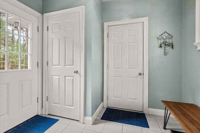 interior space featuring light tile patterned floors and baseboards