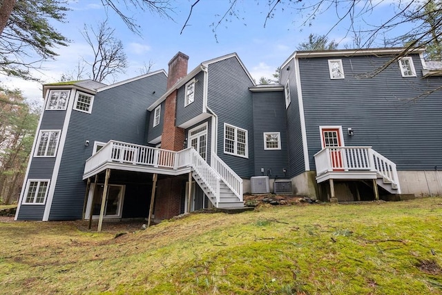 back of house with a yard, cooling unit, a chimney, and a wooden deck