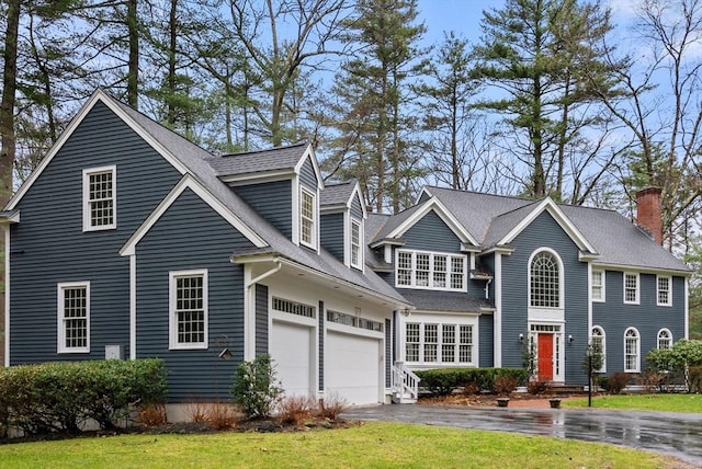 view of front facade with a garage, driveway, and roof with shingles