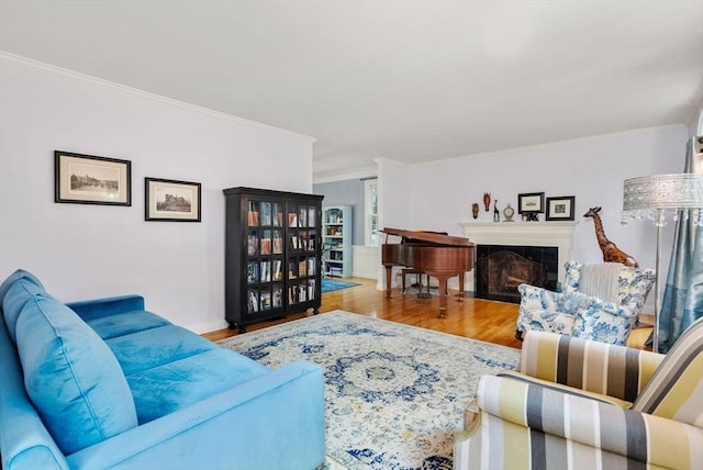 living room featuring crown molding, wood finished floors, and a fireplace with flush hearth