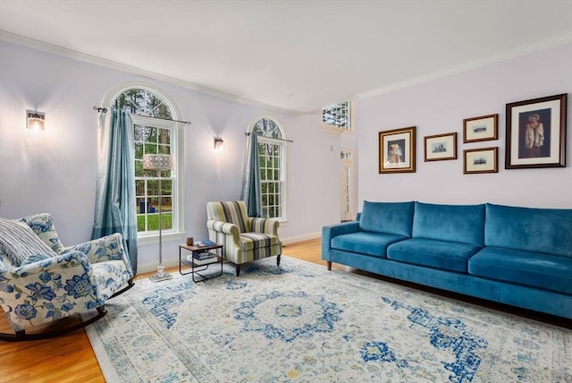 living room with light wood-type flooring, baseboards, and ornamental molding