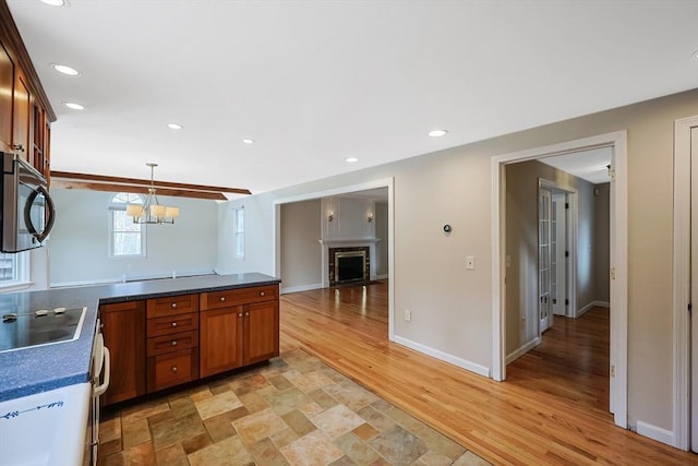 kitchen featuring decorative light fixtures, dark countertops, recessed lighting, and a fireplace