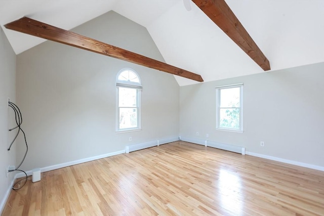 spare room with a wealth of natural light, baseboards, wood finished floors, and vaulted ceiling with beams