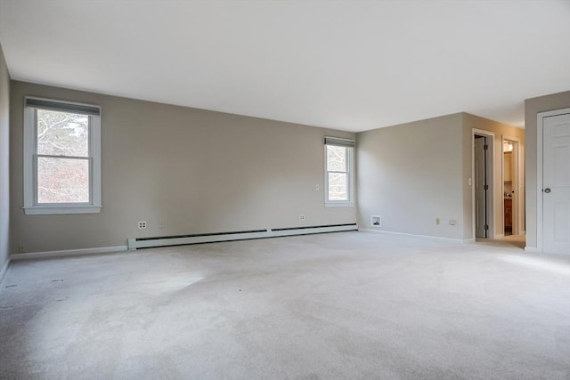 empty room with baseboards, baseboard heating, and light carpet